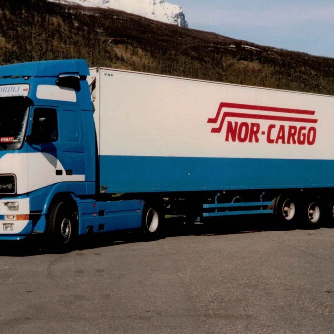 Gammelt bilde av Nor-Cargo trailer på grusplass